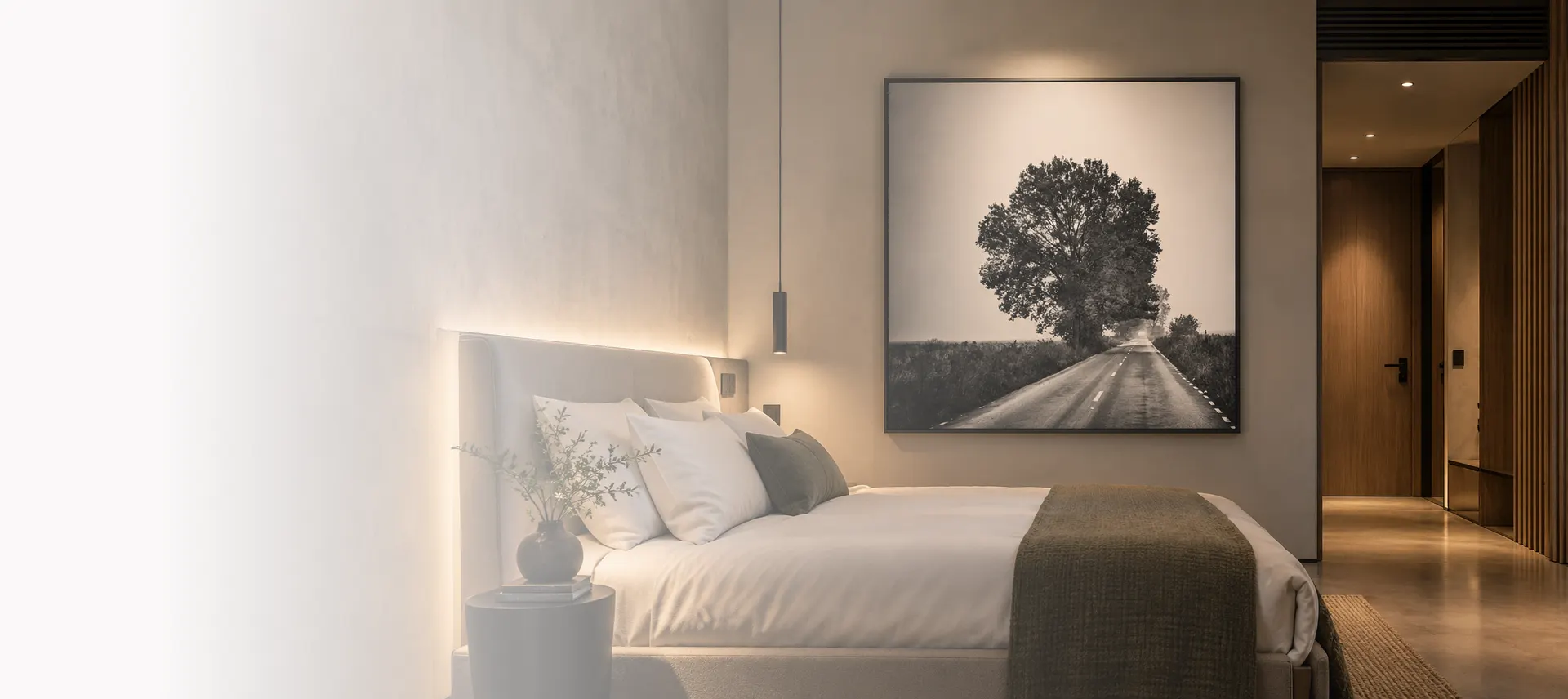 Lucrare cu peisaj în alb-negru, deasupra patului dintr-o cameră contemporană de hotel.