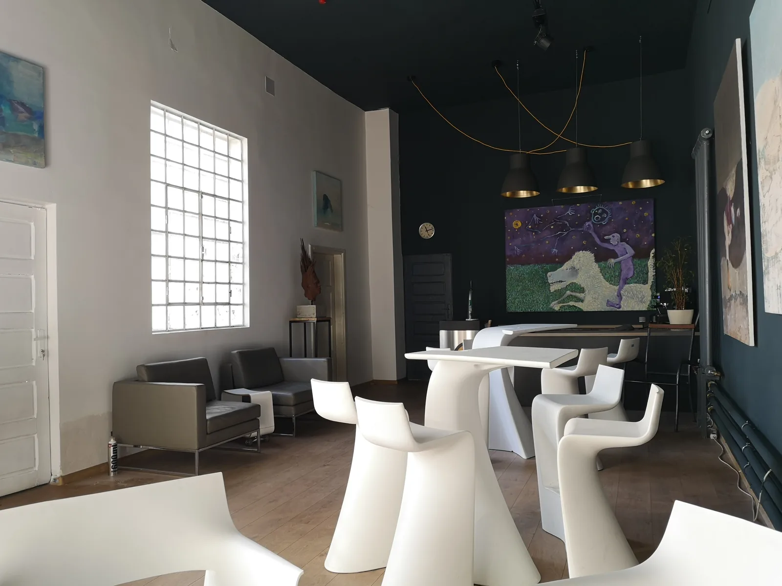 Original paintings arranged throughout the collector-room interior of ArtHalle Bistro.
