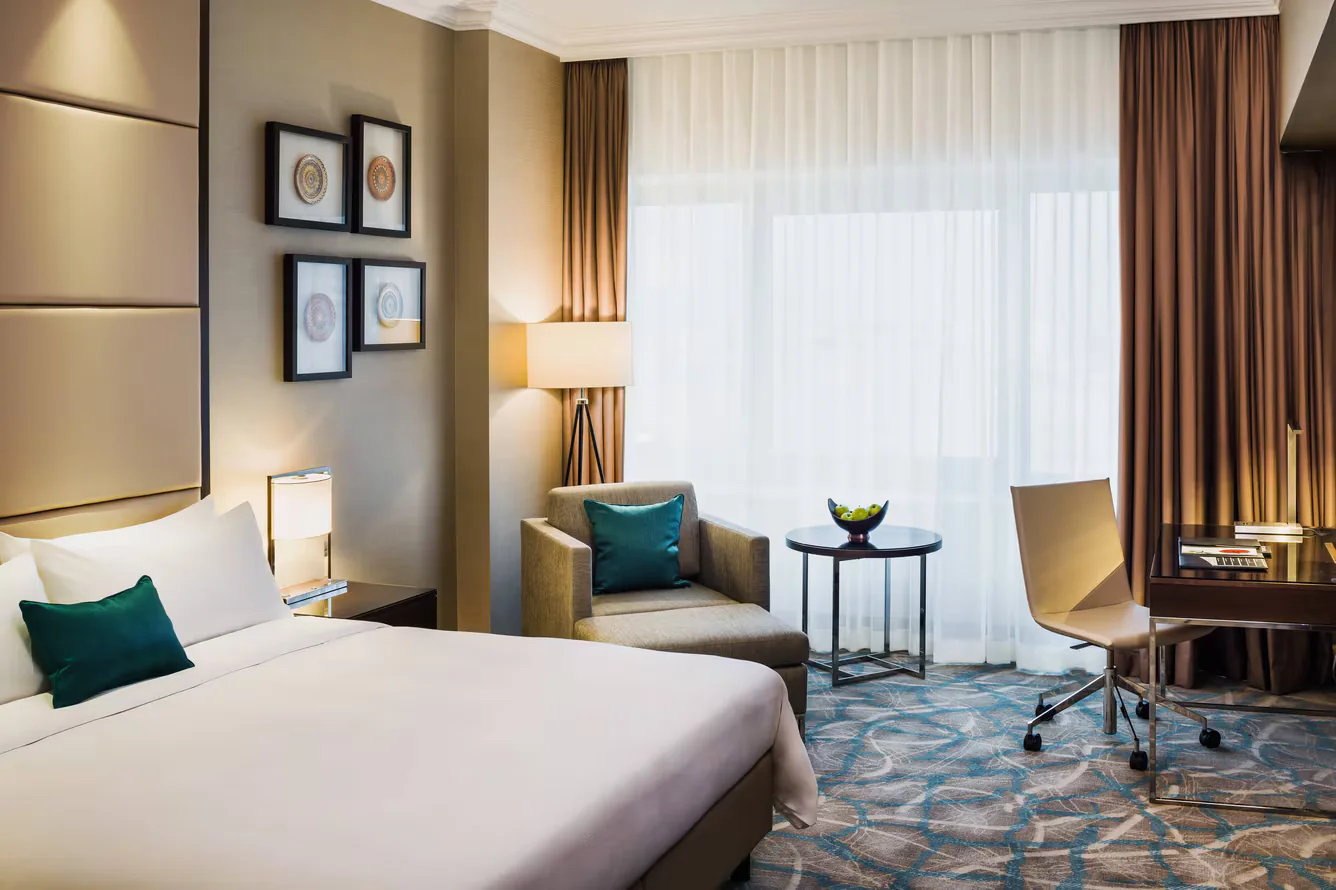 Four framed circular ceramic artworks installed beside the bed in a neutral hotel guestroom.