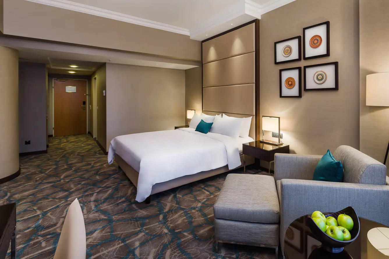 Wide hotel guestroom showing a four-piece ceramic composition integrated into the accommodation layout.