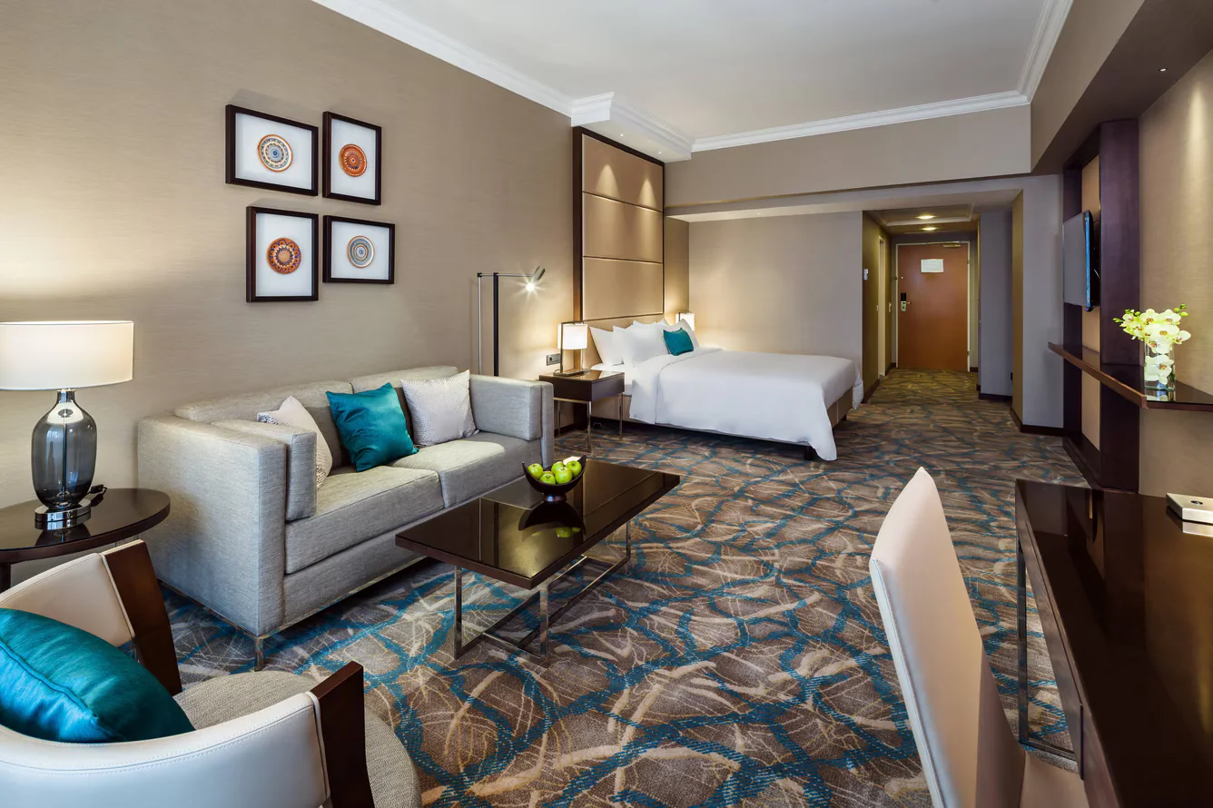 Large hotel suite with framed ceramic compositions continuing through the living and sleeping areas.